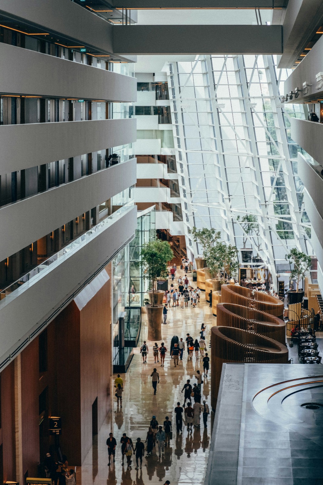 Interior of a large contemporary building with people moving through the central atrium.